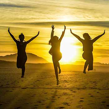 happy people jumping at sunset